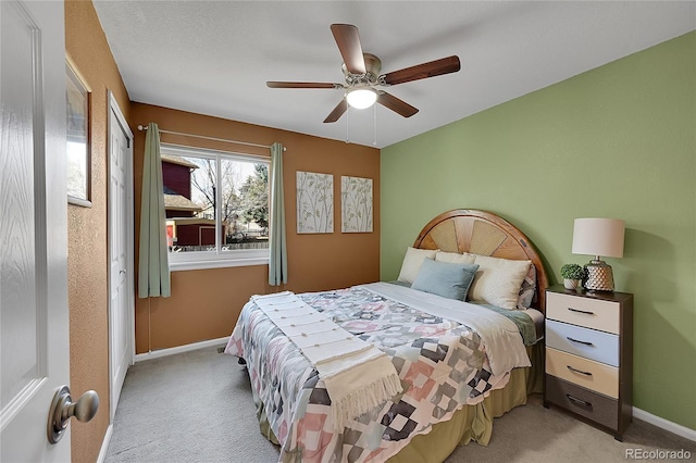 bedroom featuring light carpet, a ceiling fan, and baseboards