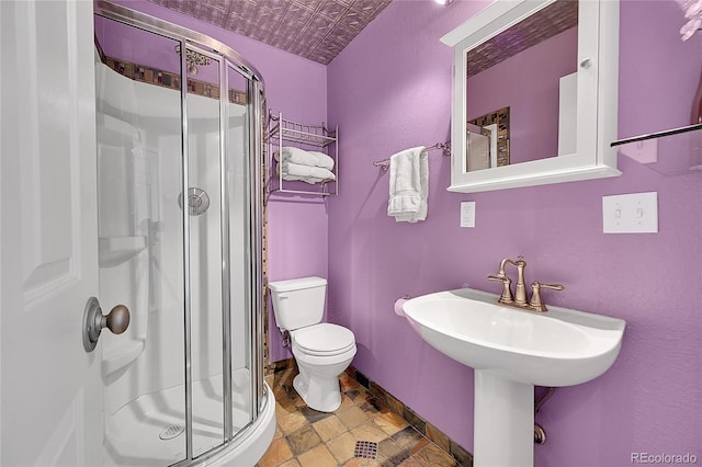 bathroom featuring toilet, a stall shower, a sink, an ornate ceiling, and baseboards