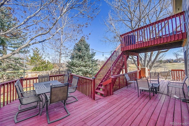 deck featuring outdoor dining space and stairway