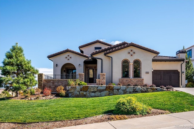 mediterranean / spanish house featuring a front lawn and a garage