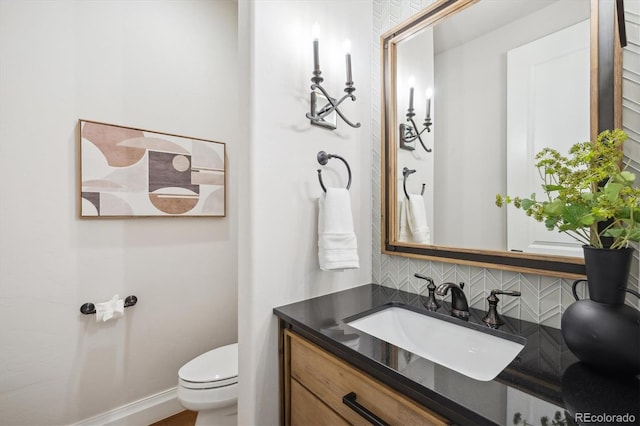 bathroom featuring vanity, toilet, and tasteful backsplash