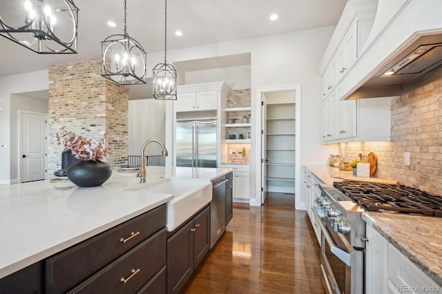 kitchen featuring premium range hood, high quality appliances, pendant lighting, decorative backsplash, and white cabinets