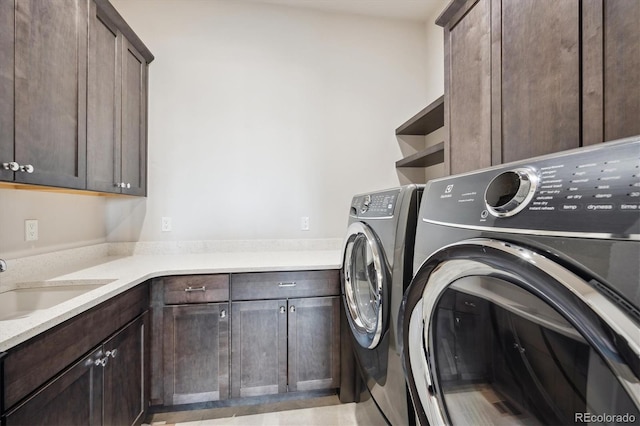 laundry area featuring cabinets, independent washer and dryer, and sink