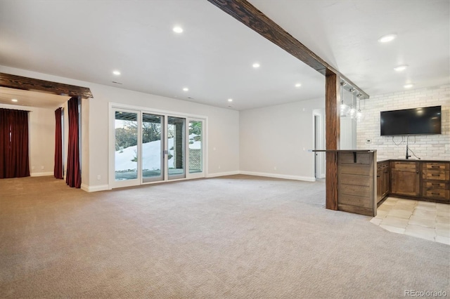 unfurnished living room featuring light colored carpet and sink