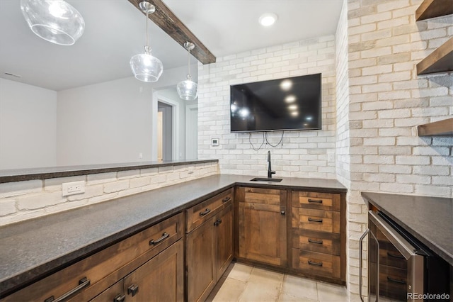 kitchen with hanging light fixtures, sink, light tile patterned floors, beam ceiling, and beverage cooler