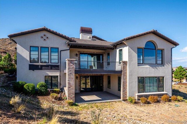 rear view of property featuring a patio and a balcony