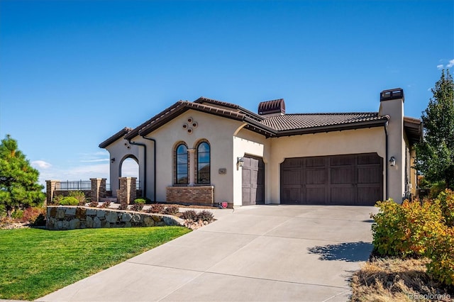 mediterranean / spanish-style house featuring a front lawn, central AC unit, and a garage