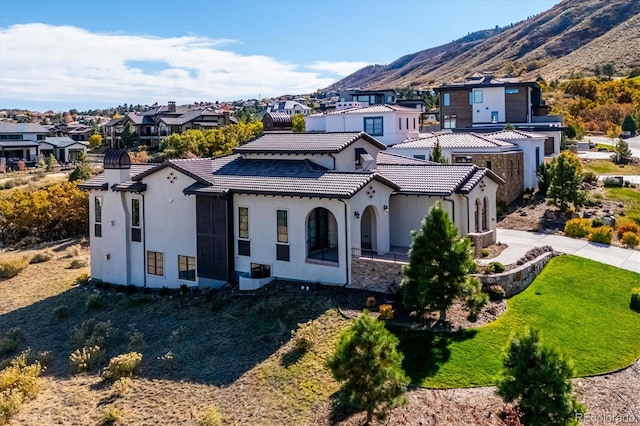 rear view of property with a mountain view and a yard