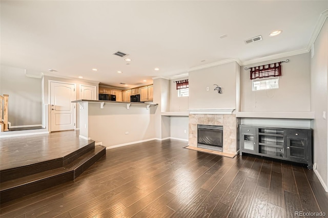 2538 Central Park Blvd, Denver, CO 80238 - unfurnished living room featuring a tile fireplace, plenty of natural light, ornamental molding, wood finished floors, and recessed lighting