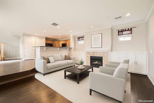 2538 Central Park Blvd, Denver, CO 80238 - living room featuring healthy amount of natural light, dark wood-style flooring, ornamental molding, a tile fireplace, and recessed lighting