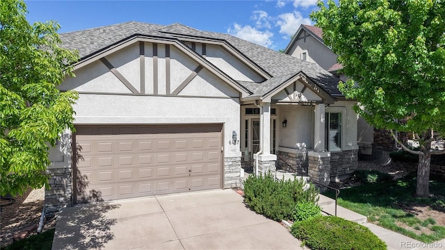 6187 Reed Way, Arvada, CO 80003 - tudor-style house featuring stone siding, stucco siding, driveway, a garage, and roof with shingles