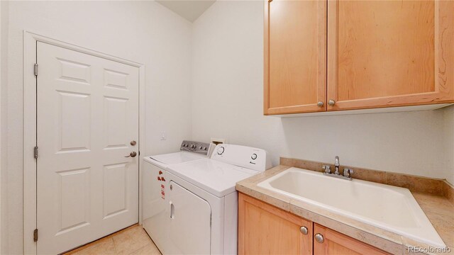 6187 Reed Way, Arvada, CO 80003 - washroom with washing machine and clothes dryer, cabinet space, and light tile patterned flooring