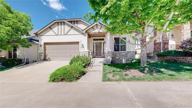 6187 Reed Way, Arvada, CO 80003 - view of front of house featuring stucco siding, concrete driveway, an attached garage, and stone siding