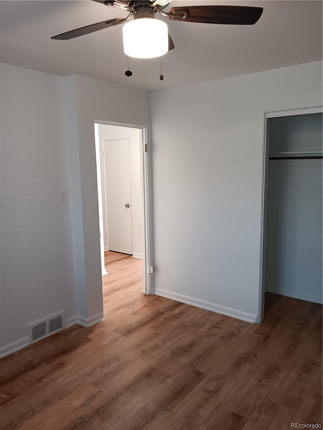 unfurnished bedroom with ceiling fan, hardwood / wood-style floors, and a closet