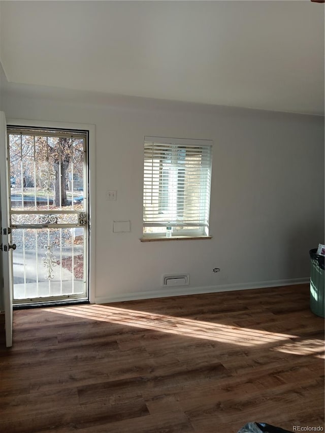 unfurnished room with dark wood-type flooring