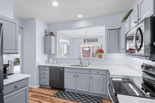 kitchen with sink, dishwasher, hanging light fixtures, range with electric stovetop, and gray cabinetry