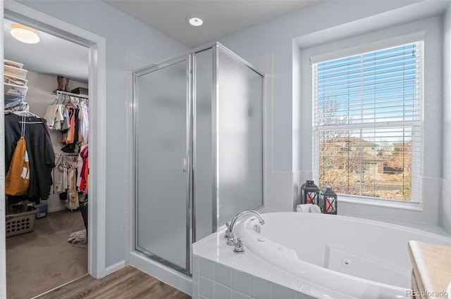 bathroom featuring plus walk in shower, a wealth of natural light, vanity, and wood-type flooring