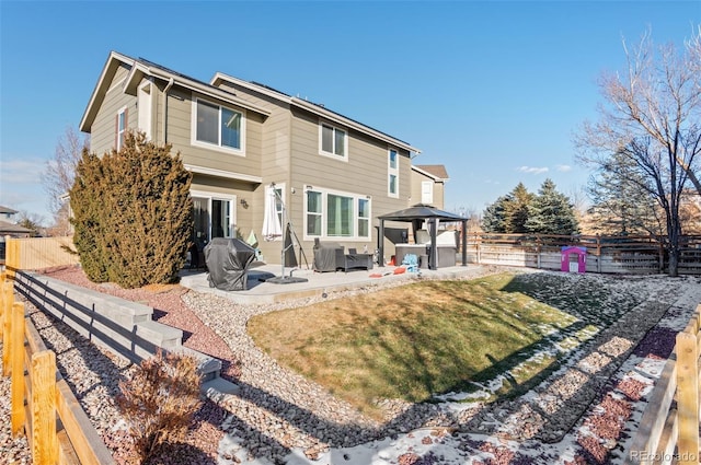 back of property with a yard, a patio area, and a gazebo