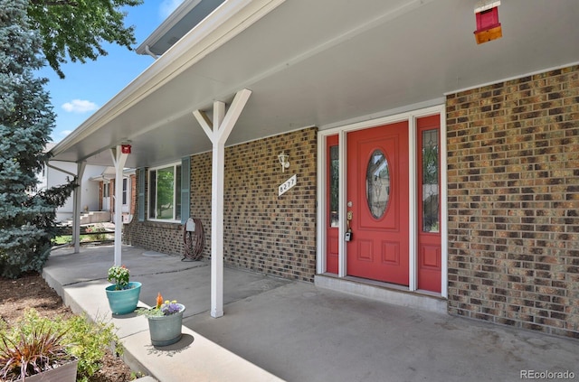 8277 Teller Ct, Arvada, CO 80003 - doorway to property featuring brick siding and covered porch