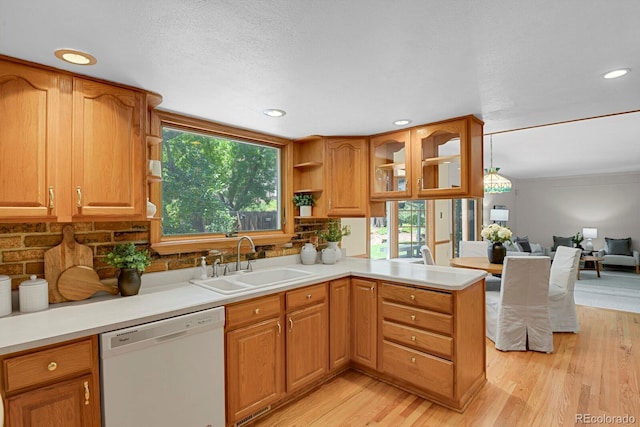 8277 Teller Ct, Arvada, CO 80003 - kitchen with white dishwasher, a peninsula, light wood-style floors, decorative backsplash, and recessed lighting