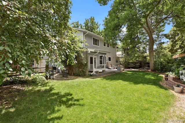 8277 Teller Ct, Arvada, CO 80003 - rear view of house featuring a lawn and a patio area
