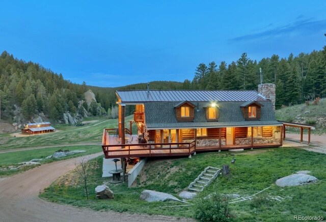60 N County Highway 67, Sedalia, CO 80135 - rear view of house featuring a view of trees, a chimney, a lawn, and a metal roof