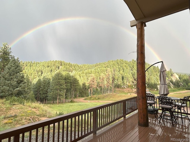 60 N County Highway 67, Sedalia, CO 80135 - wooden terrace with a wooded view, outdoor dining area, and a lawn