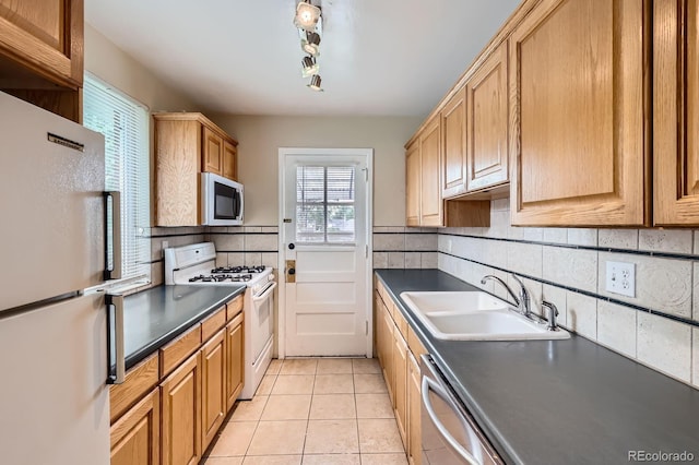 1325 Geneva St, Aurora, CO 80010 - kitchen featuring white appliances, a sink, dark countertops, and decorative backsplash