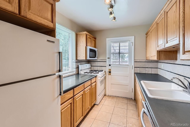 1325 Geneva St, Aurora, CO 80010 - kitchen with white appliances, a sink, dark countertops, decorative backsplash, and light tile patterned flooring