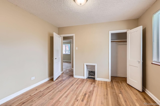 1325 Geneva St, Aurora, CO 80010 - unfurnished bedroom with light wood-style flooring, a closet, a textured ceiling, and baseboards