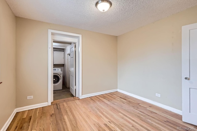 1325 Geneva St, Aurora, CO 80010 - unfurnished room with washer / clothes dryer, light wood finished floors, baseboards, and a textured ceiling