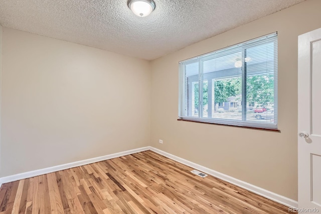 1325 Geneva St, Aurora, CO 80010 - unfurnished room with light wood-style floors, baseboards, and a textured ceiling