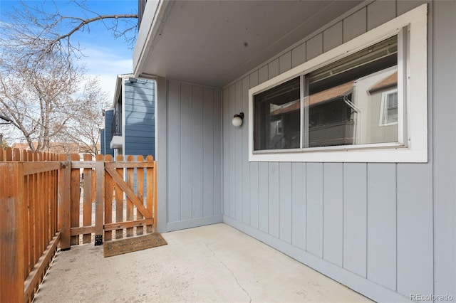 view of exterior entry featuring a patio area and fence