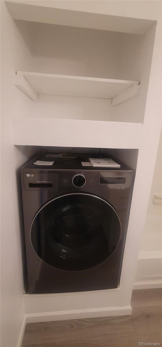 7185 S Gaylord St Unit G13, Littleton, CO 80122 - detailed view of washer / dryer, baseboards, and wood finished floors