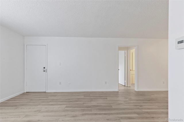 7185 S Gaylord St Unit G13, Littleton, CO 80122 - empty room featuring a textured ceiling, light wood-type flooring, and baseboards