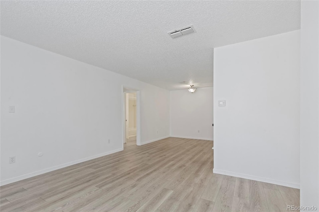 7185 S Gaylord St Unit G13, Littleton, CO 80122 - unfurnished room with light wood finished floors, a textured ceiling, and baseboards