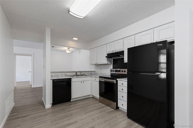 7185 S Gaylord St Unit G13, Littleton, CO 80122 - kitchen with black appliances, extractor fan, white cabinetry, a textured ceiling, and light wood-style flooring