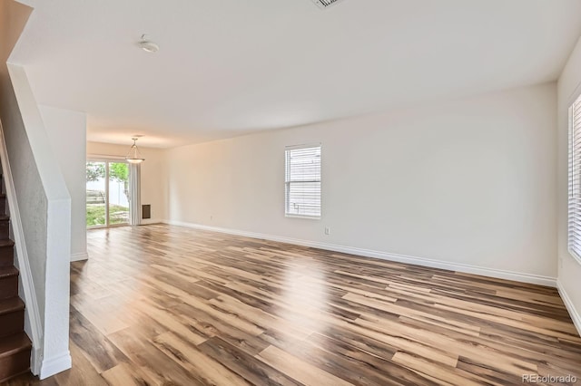 5120 Perth St, Denver, CO 80249 - unfurnished living room with stairs, wood finished floors, and baseboards