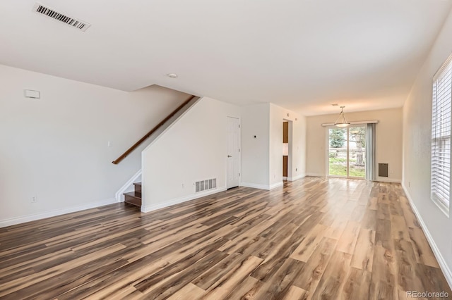 5120 Perth St, Denver, CO 80249 - unfurnished living room featuring wood finished floors, stairway, and baseboards