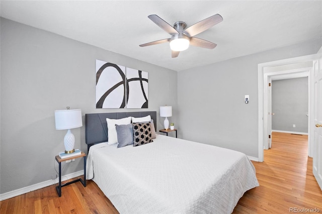 bedroom featuring ceiling fan, baseboards, and wood finished floors