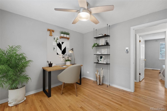 home office with a ceiling fan, light wood-type flooring, and baseboards