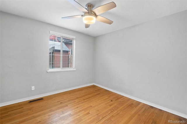 spare room with visible vents, ceiling fan, light wood-type flooring, and baseboards