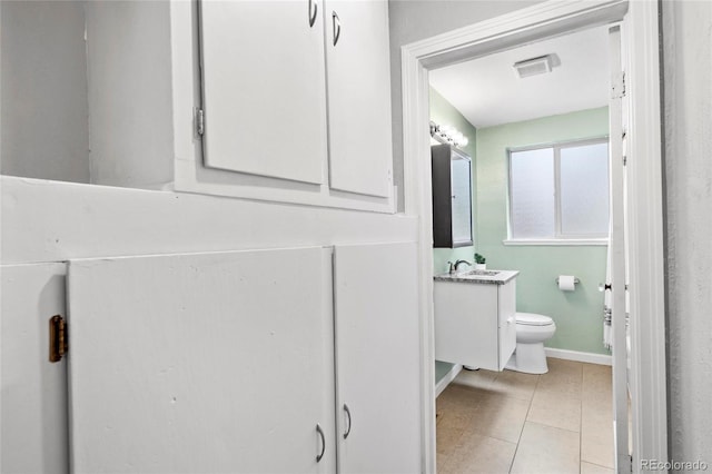 bathroom featuring vanity, visible vents, baseboards, tile patterned flooring, and toilet