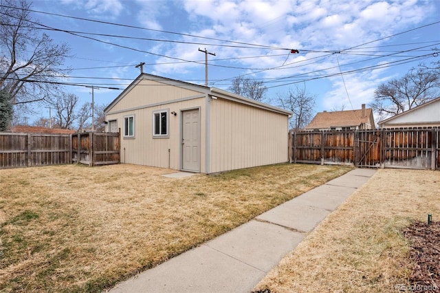 view of outdoor structure with a fenced backyard and a gate