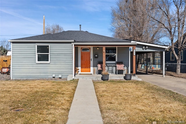 bungalow with a porch, fence, a carport, and a front lawn