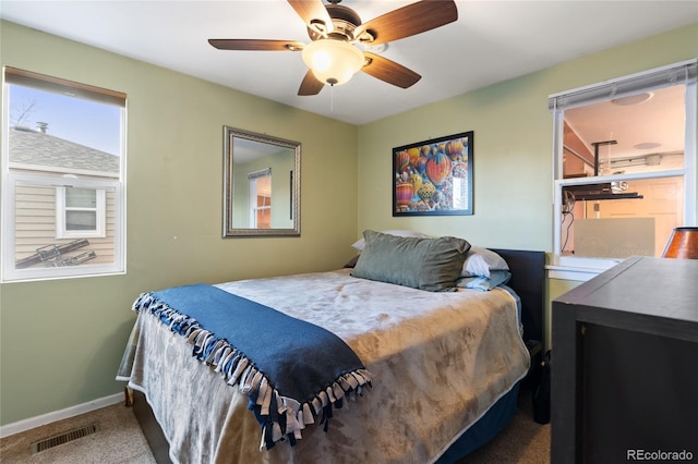 carpeted bedroom featuring baseboards, visible vents, and ceiling fan