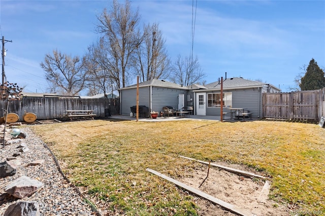 back of property with a patio, a lawn, and a fenced backyard