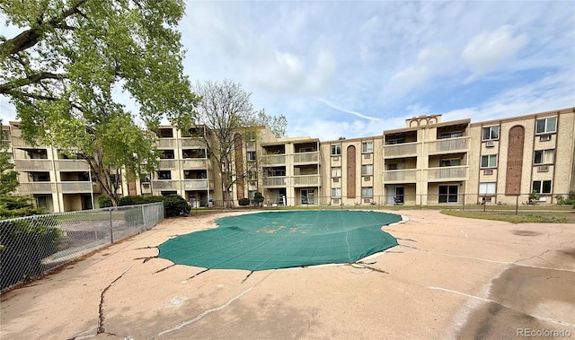 community pool with fence and a patio