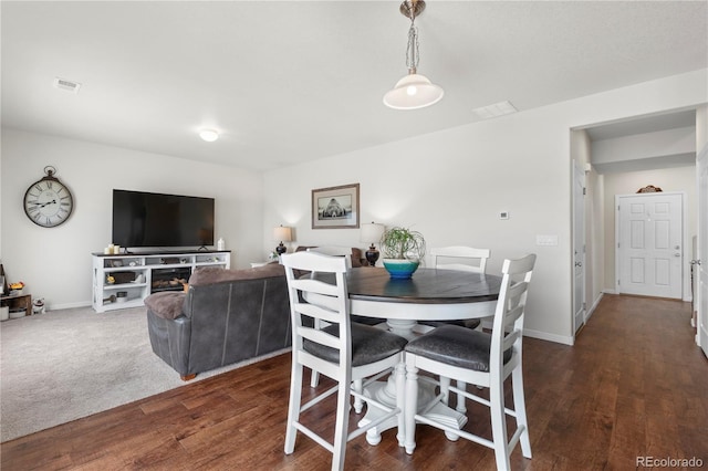 dining area featuring a fireplace and dark hardwood / wood-style floors