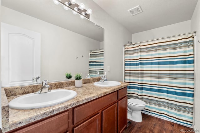 bathroom featuring vanity, wood-type flooring, toilet, and walk in shower